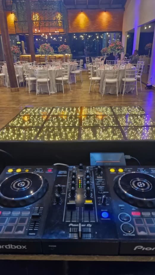 Controladora Pioneer DJ com pista iluminada e salão decorado