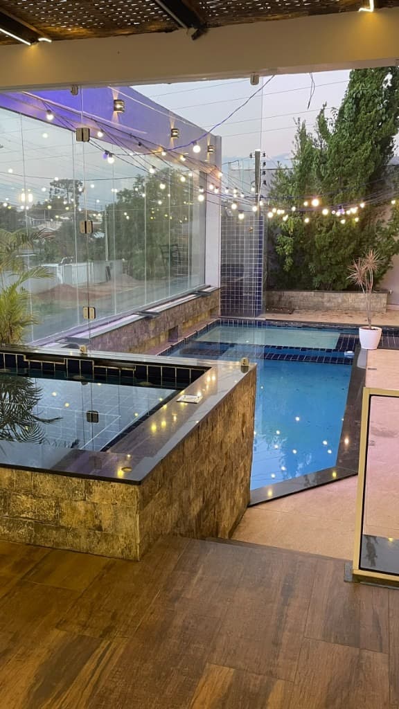 Piscina e hidromassagem com luzes de festa ao anoitecer
