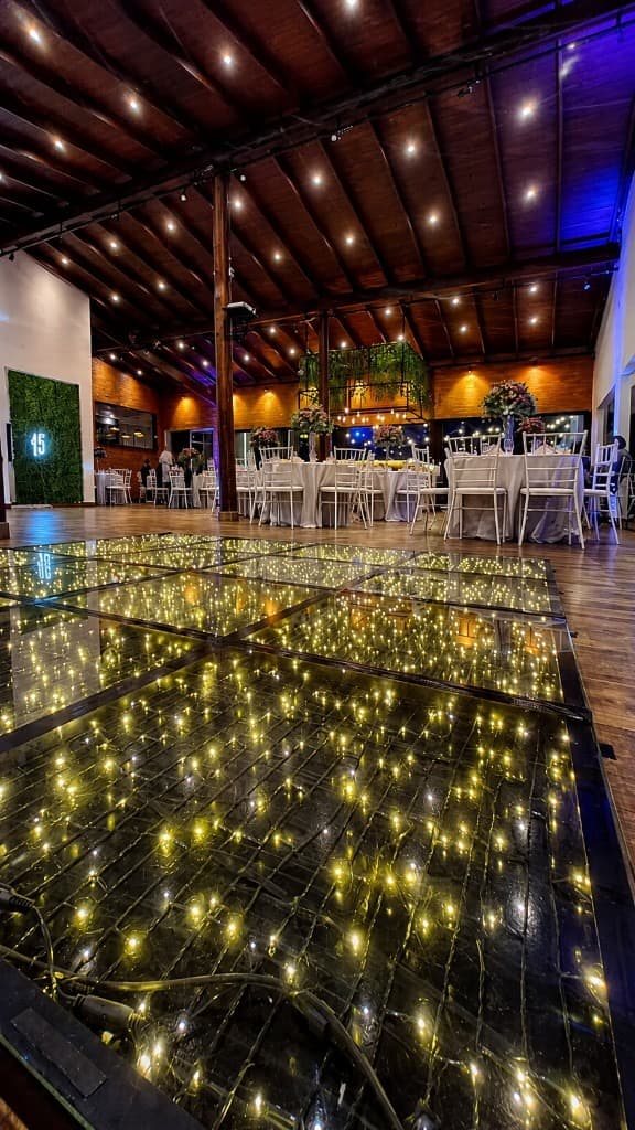Salão decorado para debutante com pista iluminada e neon numérico